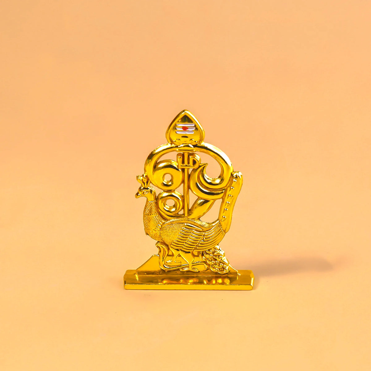 Gold decorative item on a peach background