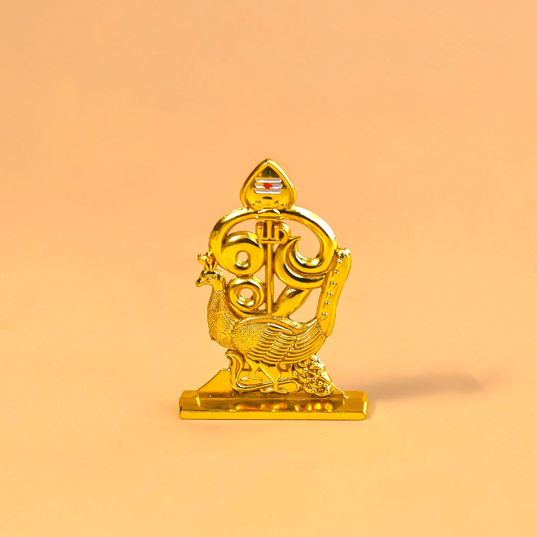 Gold decorative item on a peach backgroundMurugan 1 Peacock Vel – Abhimantrit & Certified