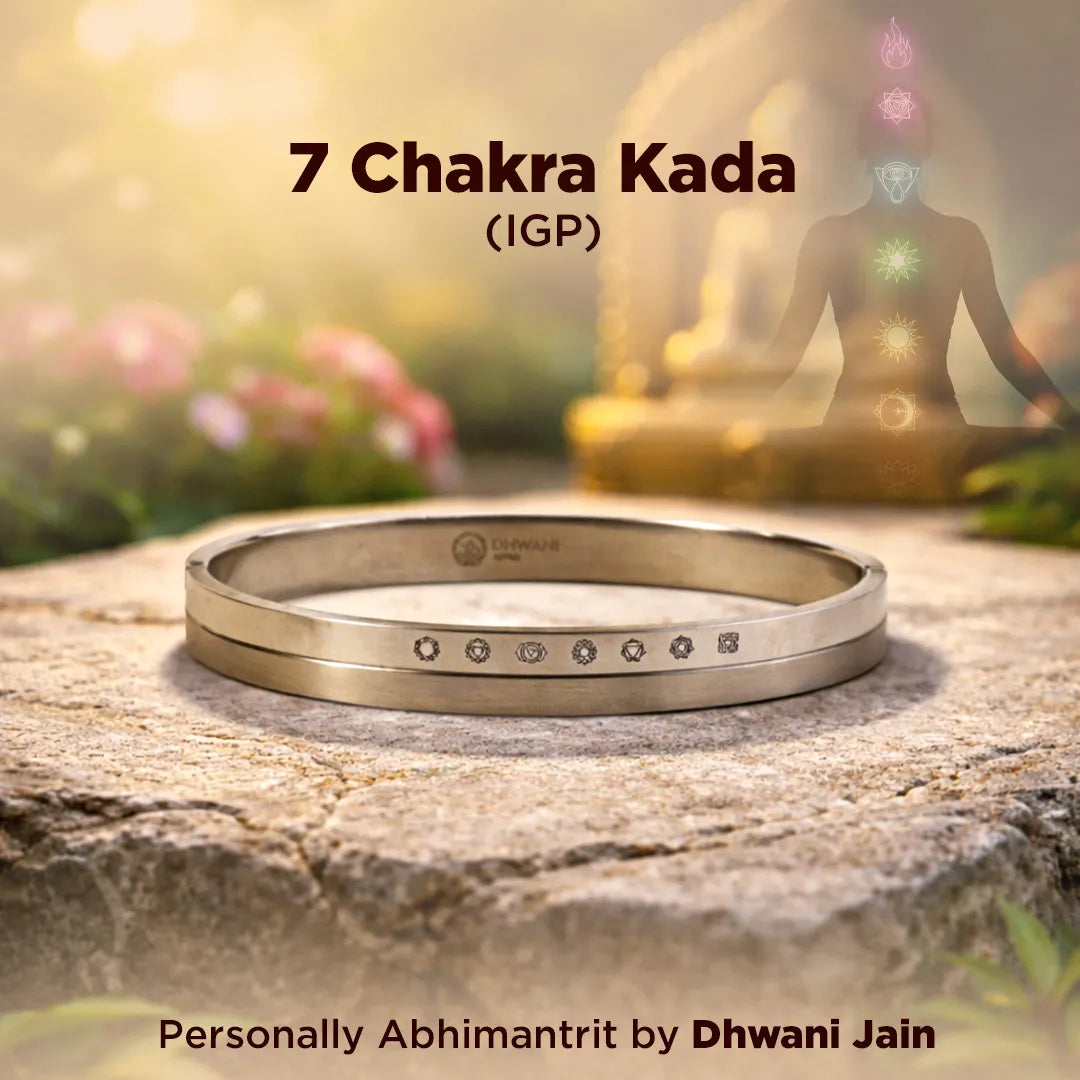 Gold bracelet on a rock with a blurred figure of a person and chakra colors in the background7 Chakra Kada – IGP Gold Plated Spiritual Kada for Energy Balance