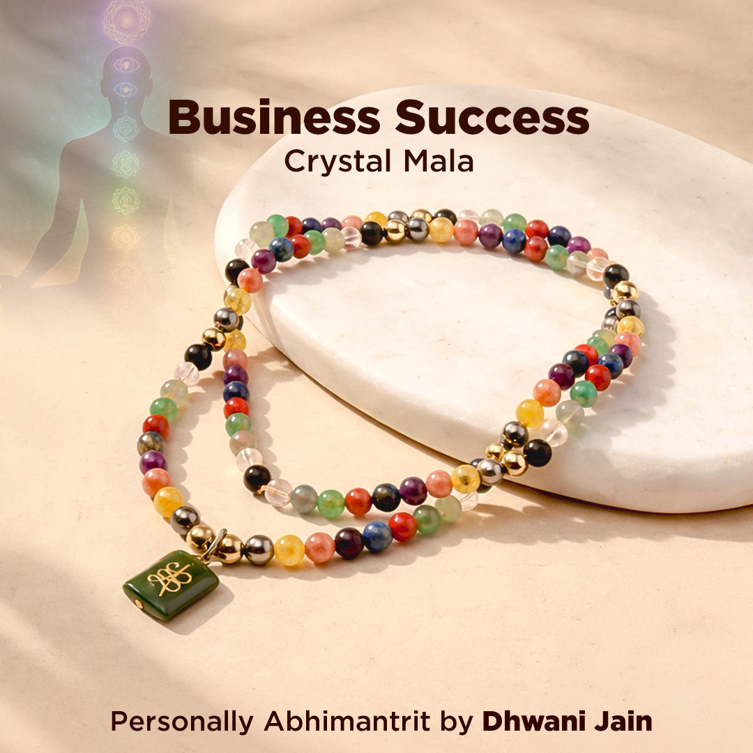 Colorful crystal mala bracelet on a white stone with 'Business Success' text and 'Dhwani Jain' branding.