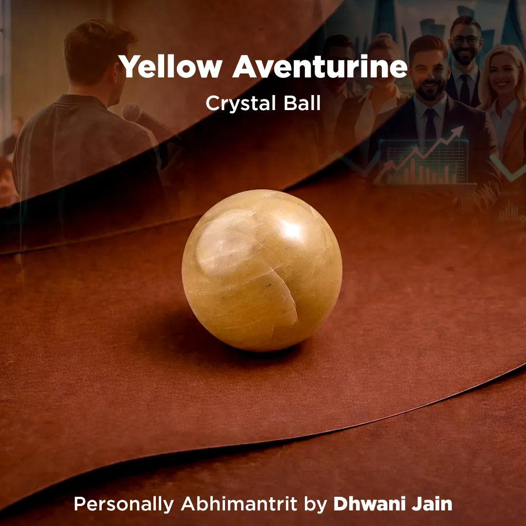 Yellow aventurine crystal ball on a brown surface with people in the background
