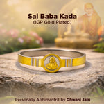 Gold-plated Sai Baba Kada bracelet on a stone surface with a blurred background
