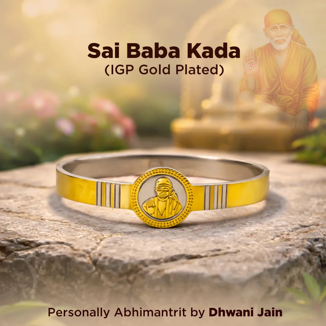 Gold-plated Sai Baba Kada bracelet on a stone surface with a blurred background