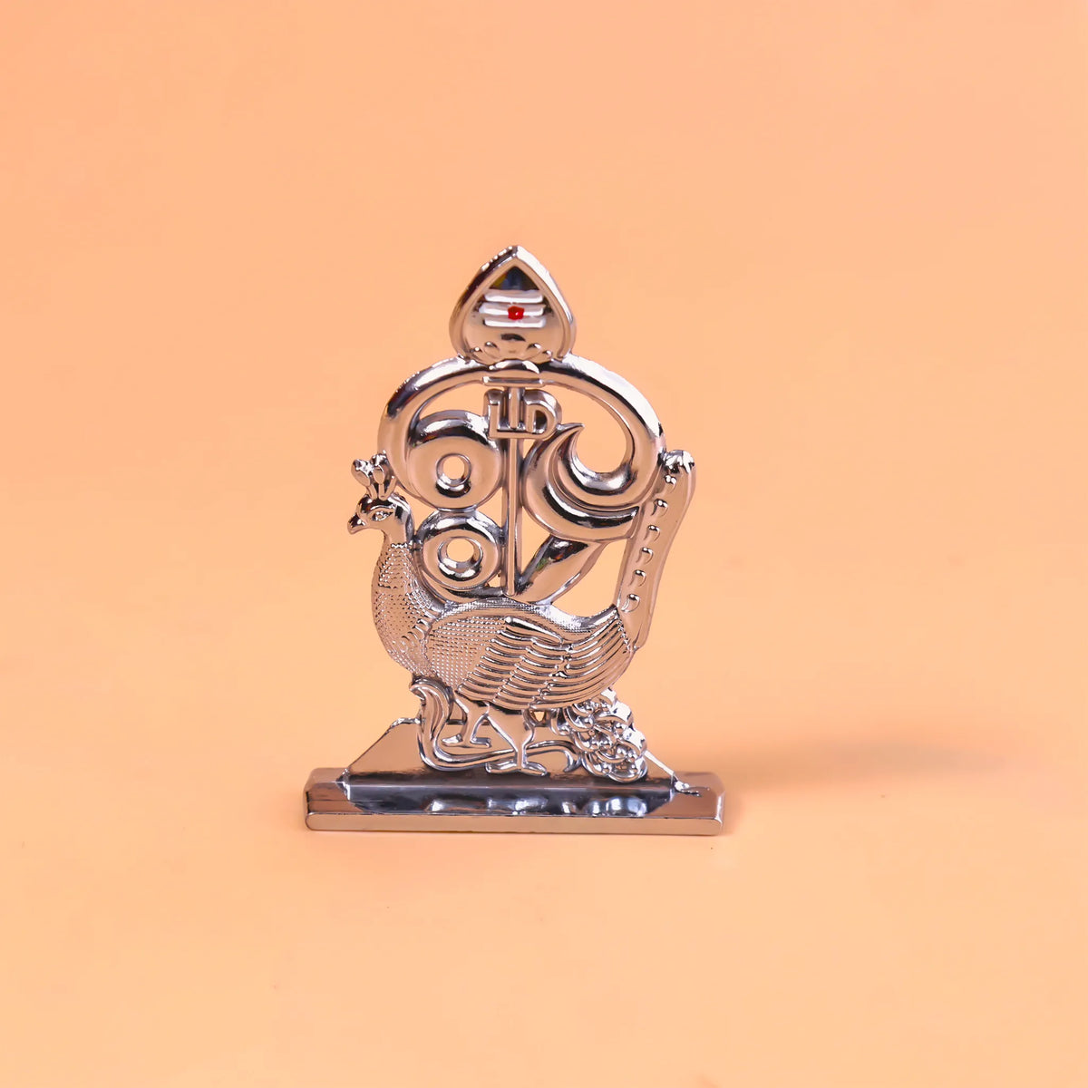 Decorative metal emblem with a peacock design on an orange background