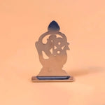 Metallic sculpture of a seated figure on an orange background