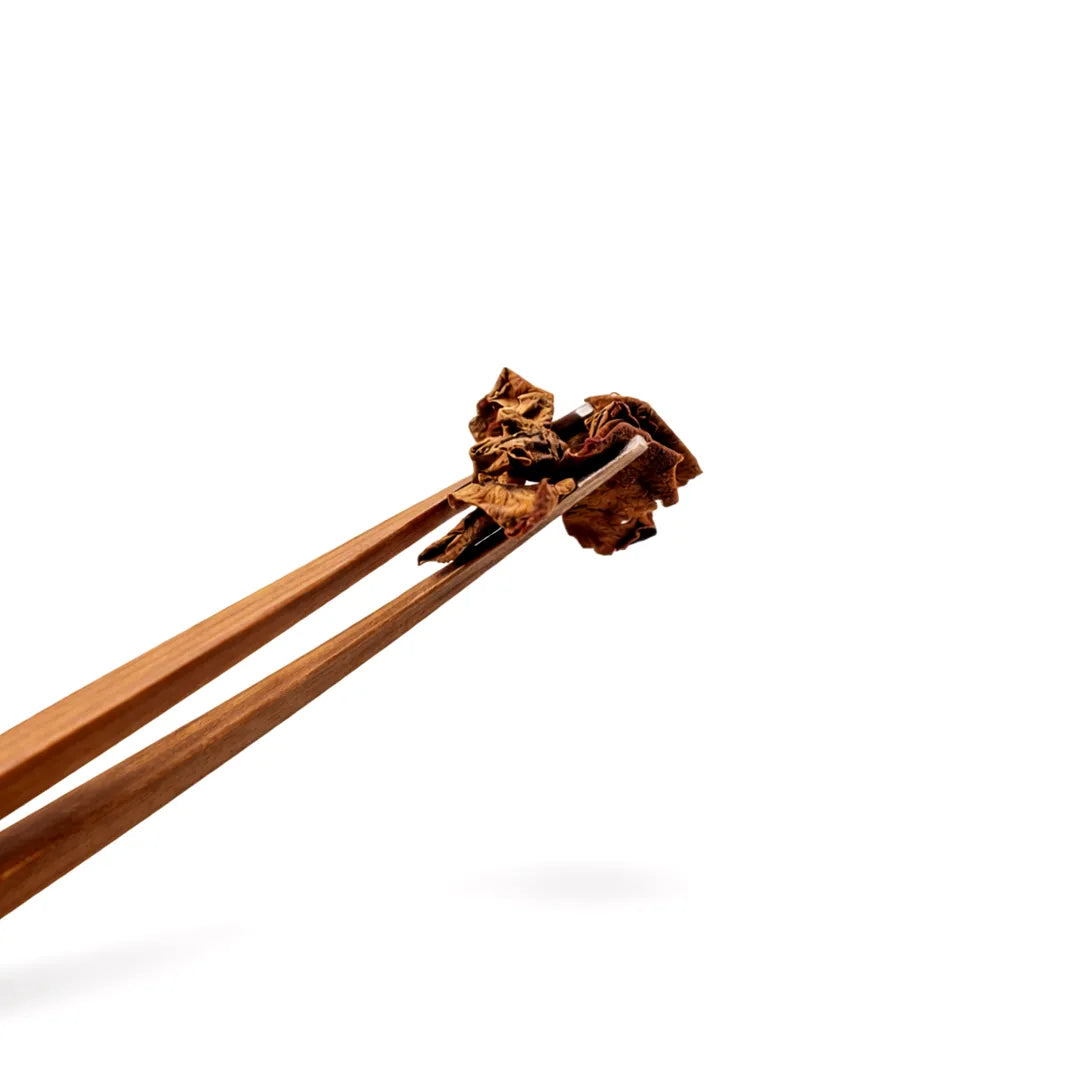 Wooden chopsticks holding a piece of food on a white backgroundDry Lotus Flower – Auspicious Symbol for Prosperity, Purity & Spiritual Growth