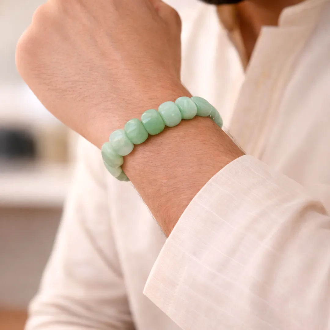 Person wearing a light green beaded bracelet on a blurred backgroundGreen Aventurine Emerald Cut Bracelet – Luck, Growth & Emotional Balance
