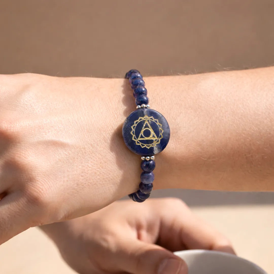 Blue beaded bracelet with a circular design on a wrist against a beige background