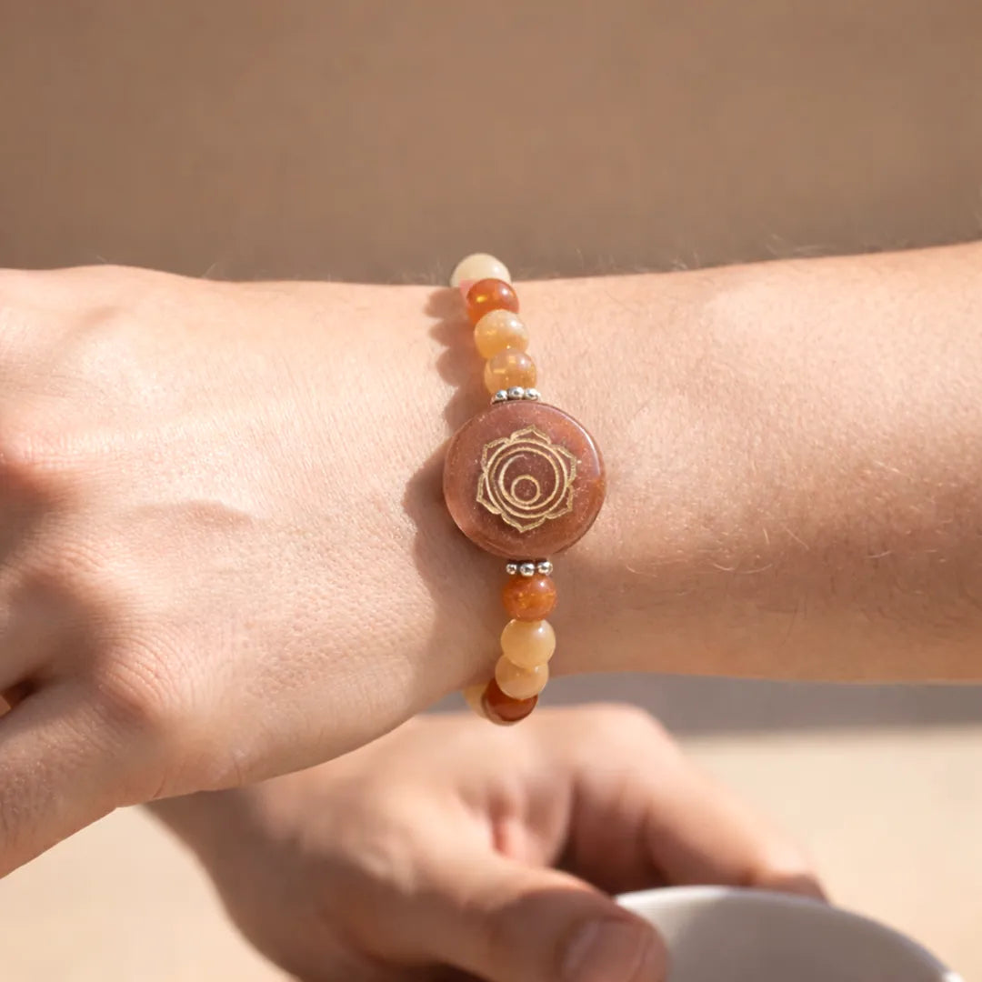 Close-up of a wrist wearing a beaded bracelet with a circular design on a neutral backgroundRed Aventurine Sacral Chakra Bracelet – Abhimantrit & Energized
