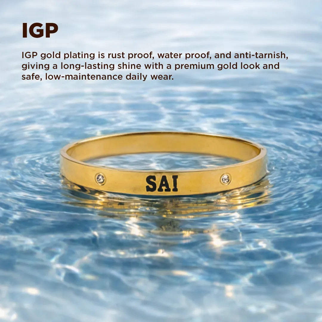 Gold bracelet with 'SAI' engraving floating in water, IGP text above.