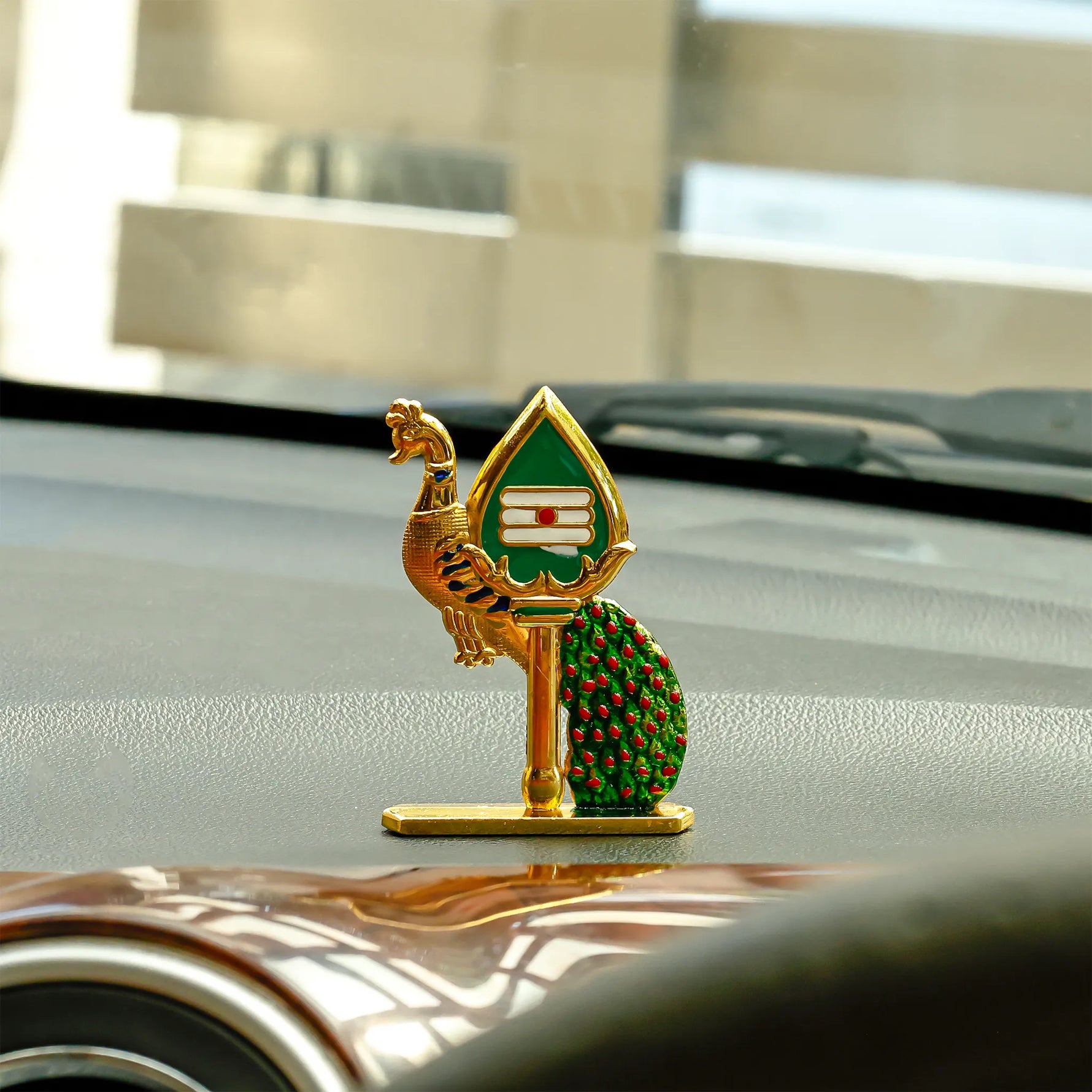 Decorative car emblem on a car's hood with a blurred backgroundPeacock Mina Vel – Divine Protection & Victory Pendant