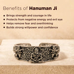 Silver bracelet with engravings on a wooden surface, featuring text about the benefits of Hanuman Ji.