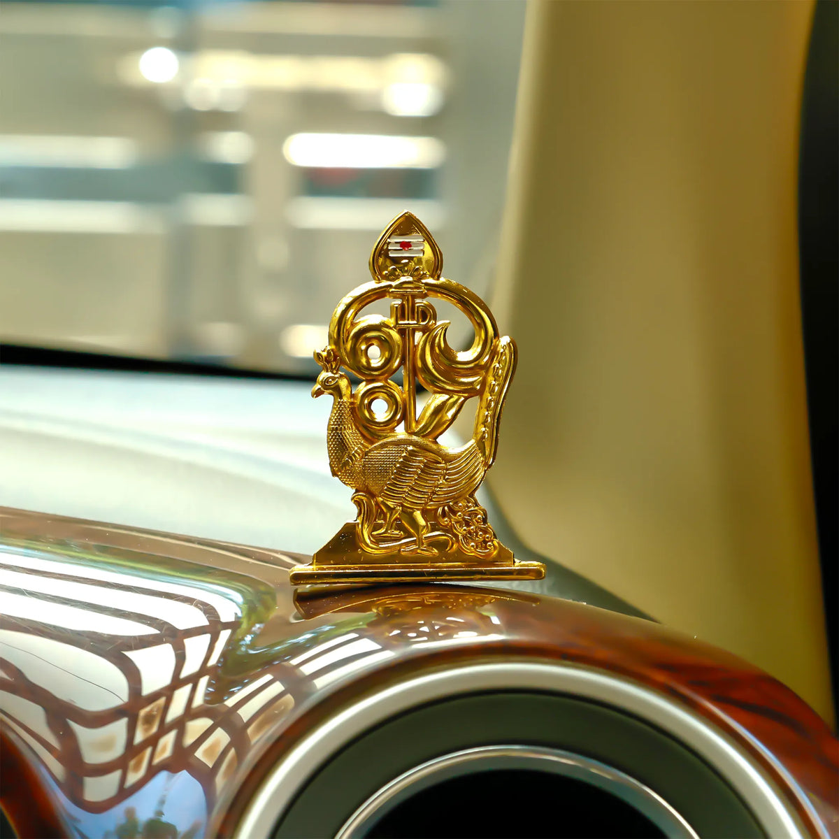 Gold car emblem on a classic car hood with blurred background