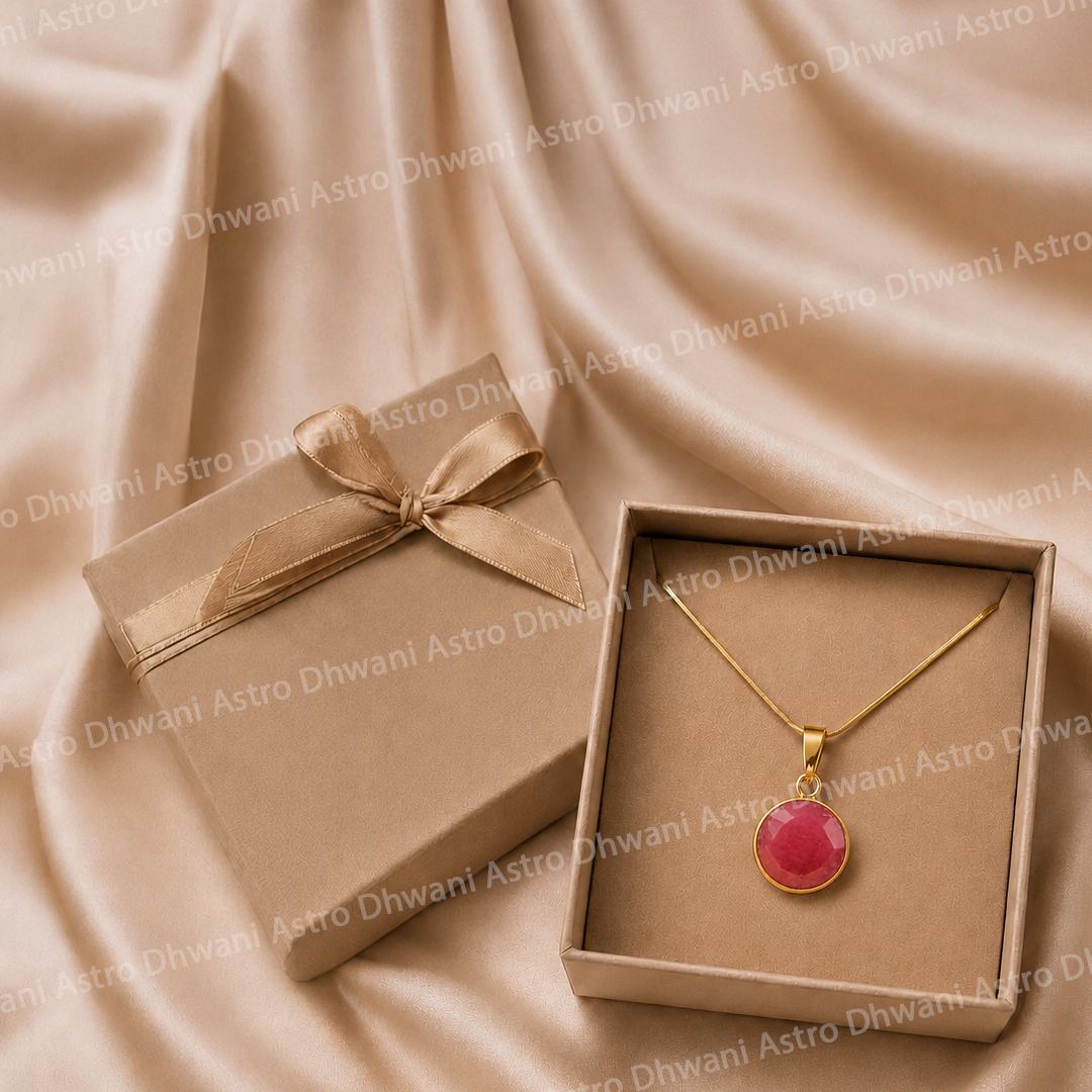 Gold necklace with a pink pendant in a box on a beige fabric background