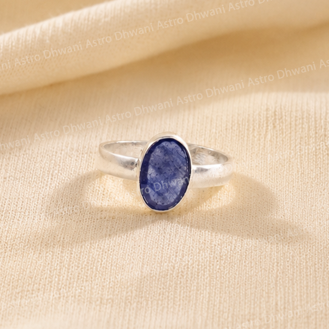 Silver ring with a blue stone on a beige fabric background
