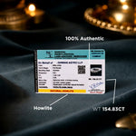 Certification card for a gemstone on a dark fabric background with candles.