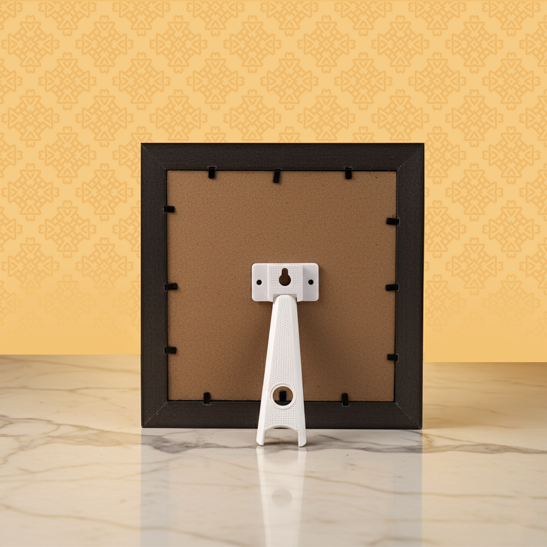 Black picture frame with a white backer on a marble surface and yellow patterned wall background