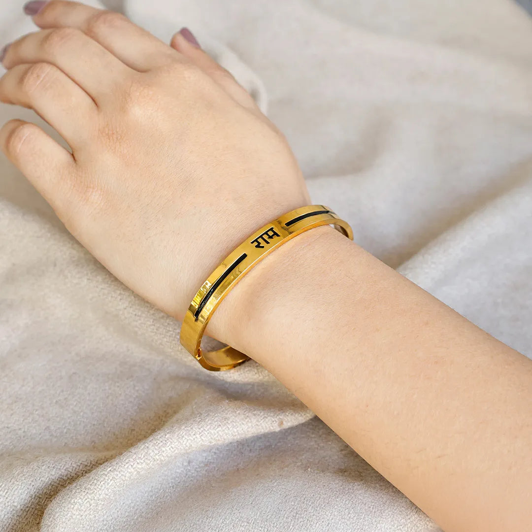 Gold bracelet with engraved text on a person's wrist against a light fabric backgroundRam Pavitra Kada (IGP Gold Plating) – Abhimantrit & Certified