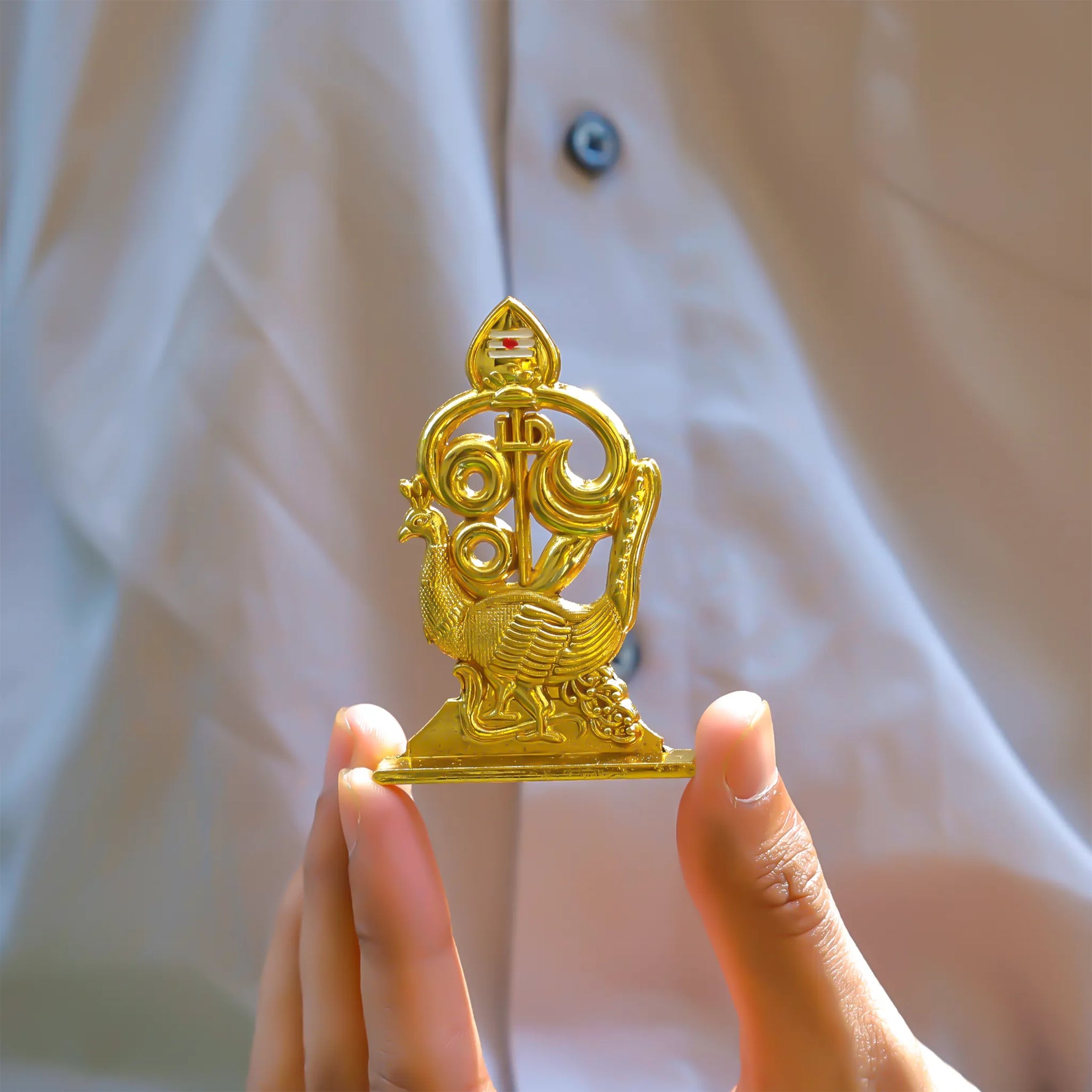 Gold decorative item held by a hand against a neutral backgroundMurugan 1 Peacock Vel – Abhimantrit & Certified