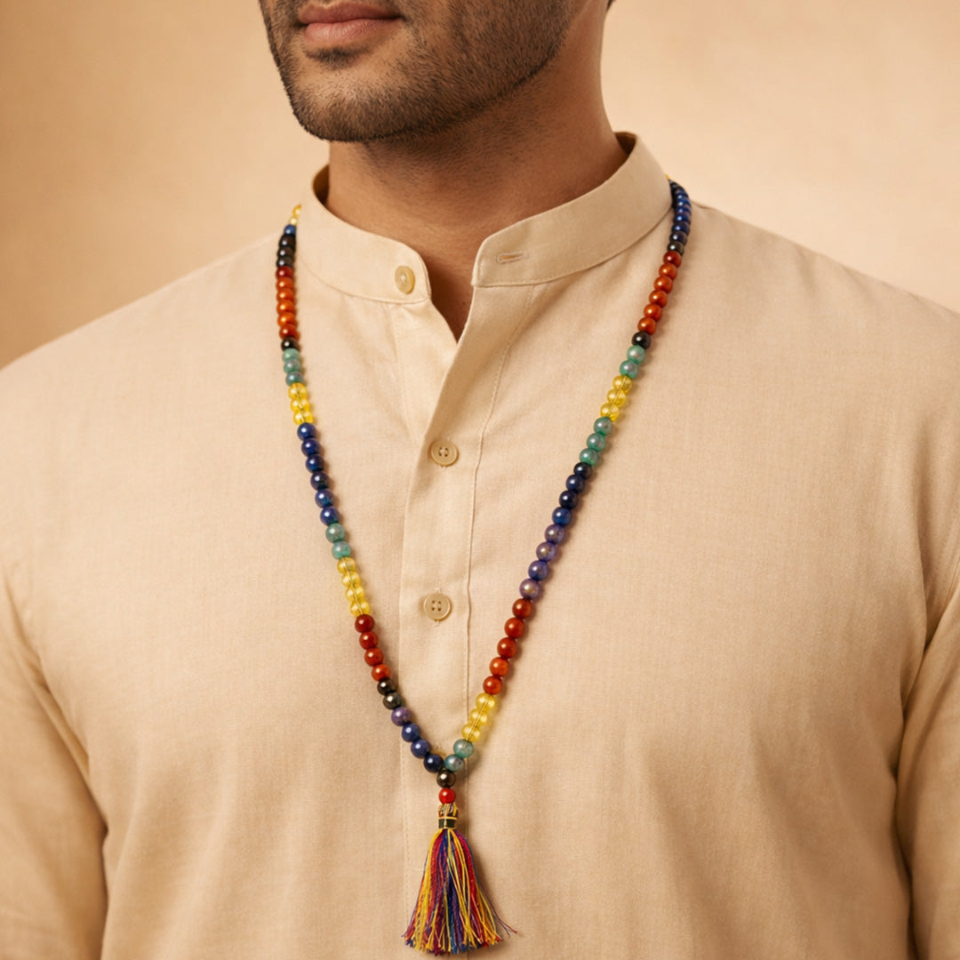Man wearing a colorful beaded necklace with a tassel on a beige backgroundसात चक्र जप माला-अभिमंत्रित एवं प्रमाणित