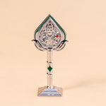 Decorative item with a figure on a stand against a beige background