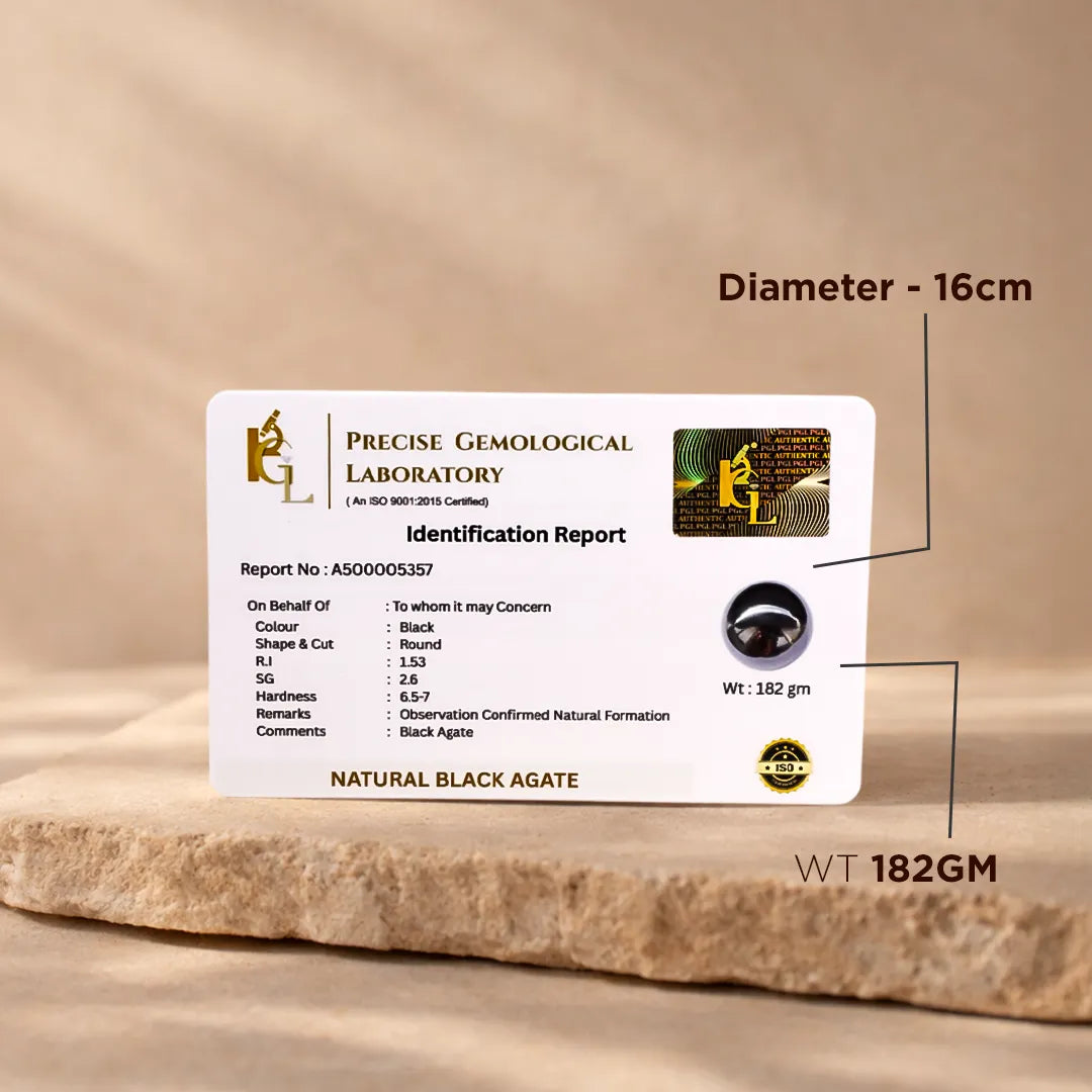 Precise Gemological Laboratory identification report card for a natural black agate on a wooden surface.Natural Black Agate Crystal Ball – Abhimantrit & Certified