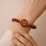 Bracelet with brown beads and a central rose design on a wrist against a beige background