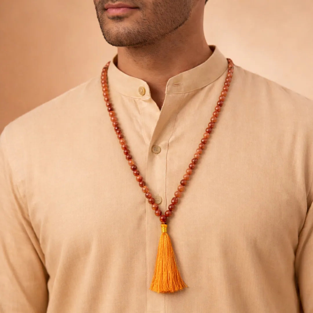 Man wearing a long beaded necklace with a yellow tassel on a beige backgroundपीली सिट्रीन जाप माला-अभिमंत्रित और प्रमाणित