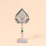 Decorative trophy with a green and silver design on a beige background