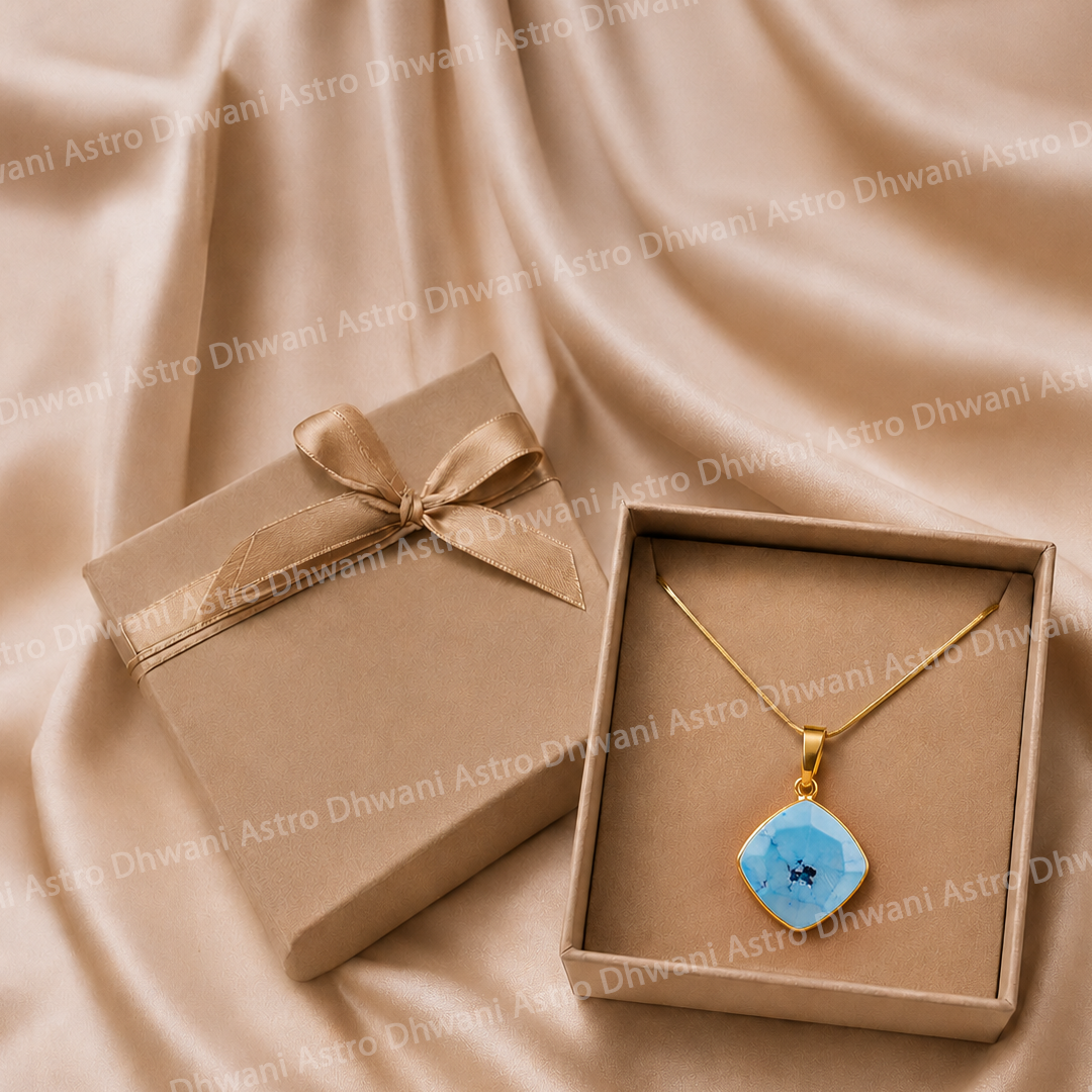 Gold necklace with a blue pendant in an open box on a beige fabric background