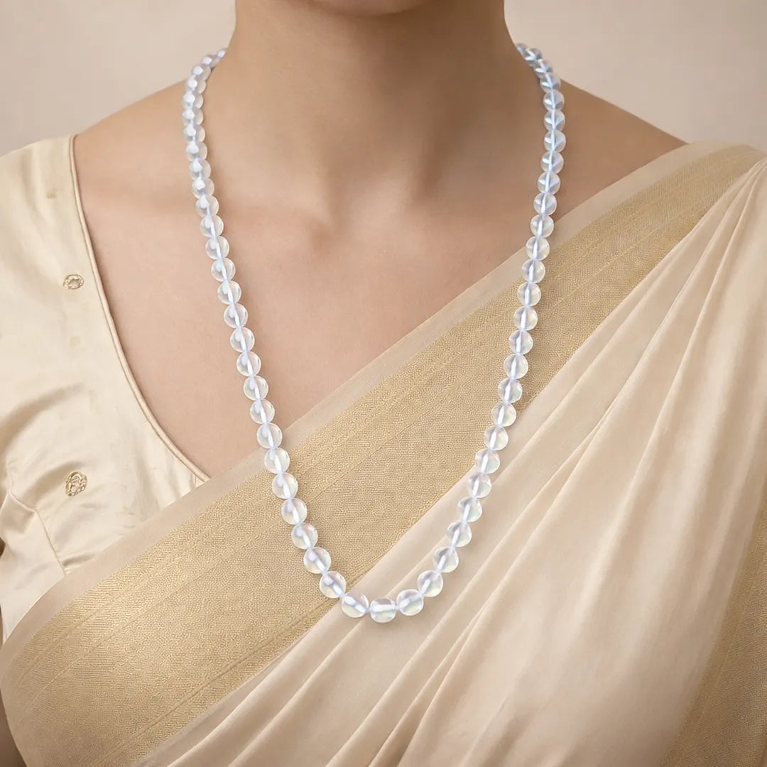 Pearl necklace worn by a person in a beige outfit