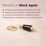 Black agate pendant with gold chain on a beige background, featuring benefits of black agate.