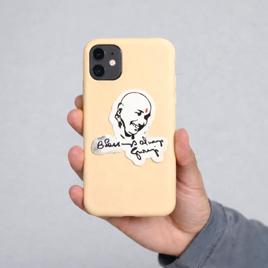 Phone case with a sticker of a face and text held by a hand against a gray background