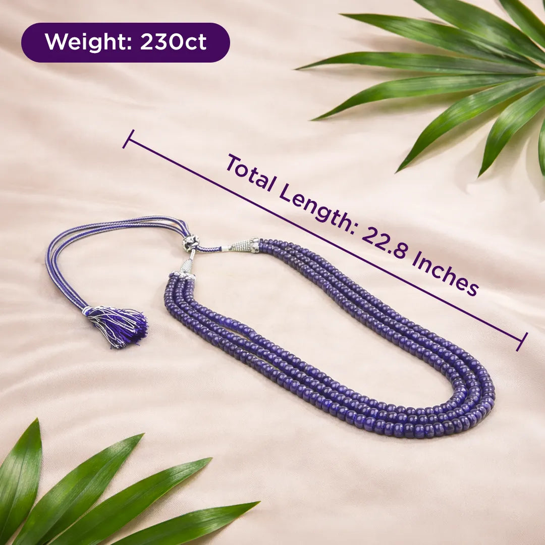 Purple beaded necklace with measurements on a beige background with green leaves.Blue Sapphire Oval Beads 3 Line Necklace for Focus, Protection & Success