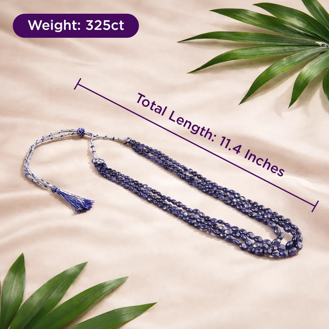 Blue beaded necklace with tassel on a beige background with green leaves, showing weight and length measurements.