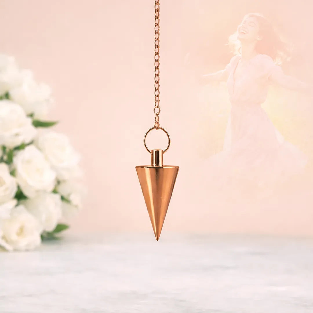 Bronze pendulum hanging against a soft, blurred background with flowers.