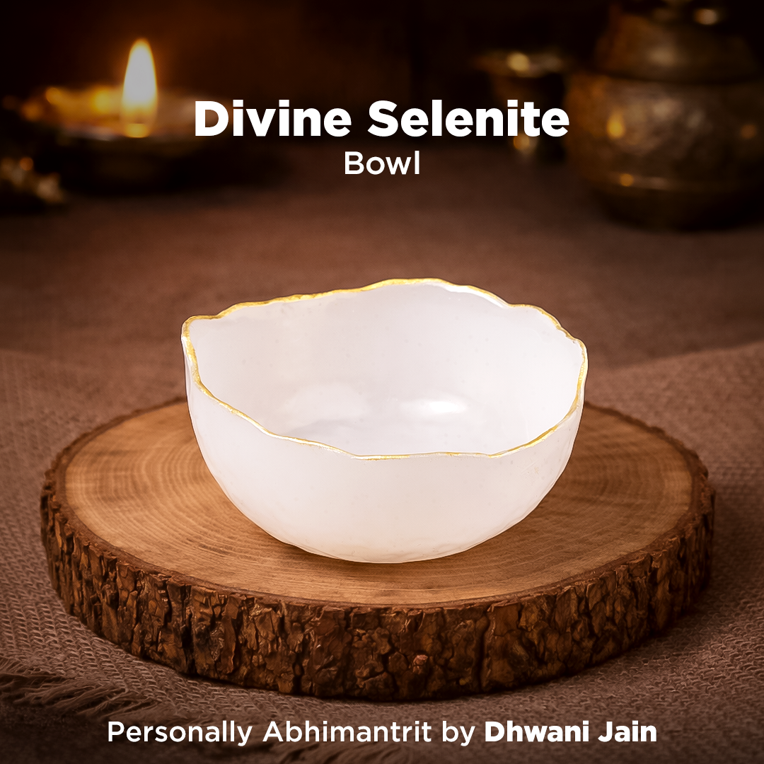 White selenite bowl on a wooden stand with a candle in the background