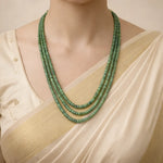 Green beaded necklace on a mannequin with a beige top
