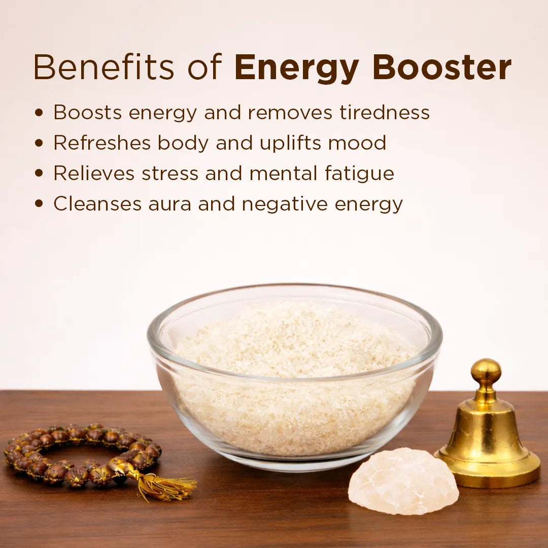 Glass bowl with white beads, a gold bell, and a bracelet on a wooden surface with text about energy booster benefits.