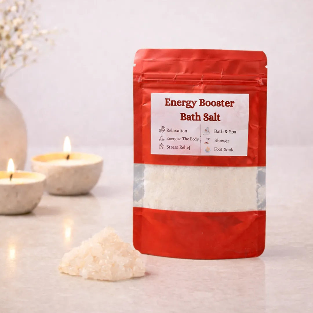 Bag of energy booster bath salt with candles and a vase in the background