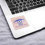 Laptop with a coaster featuring an eye design and text on the keyboard