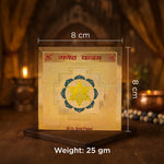 Gold-plated item with measurements and weight displayed on a wooden stand.