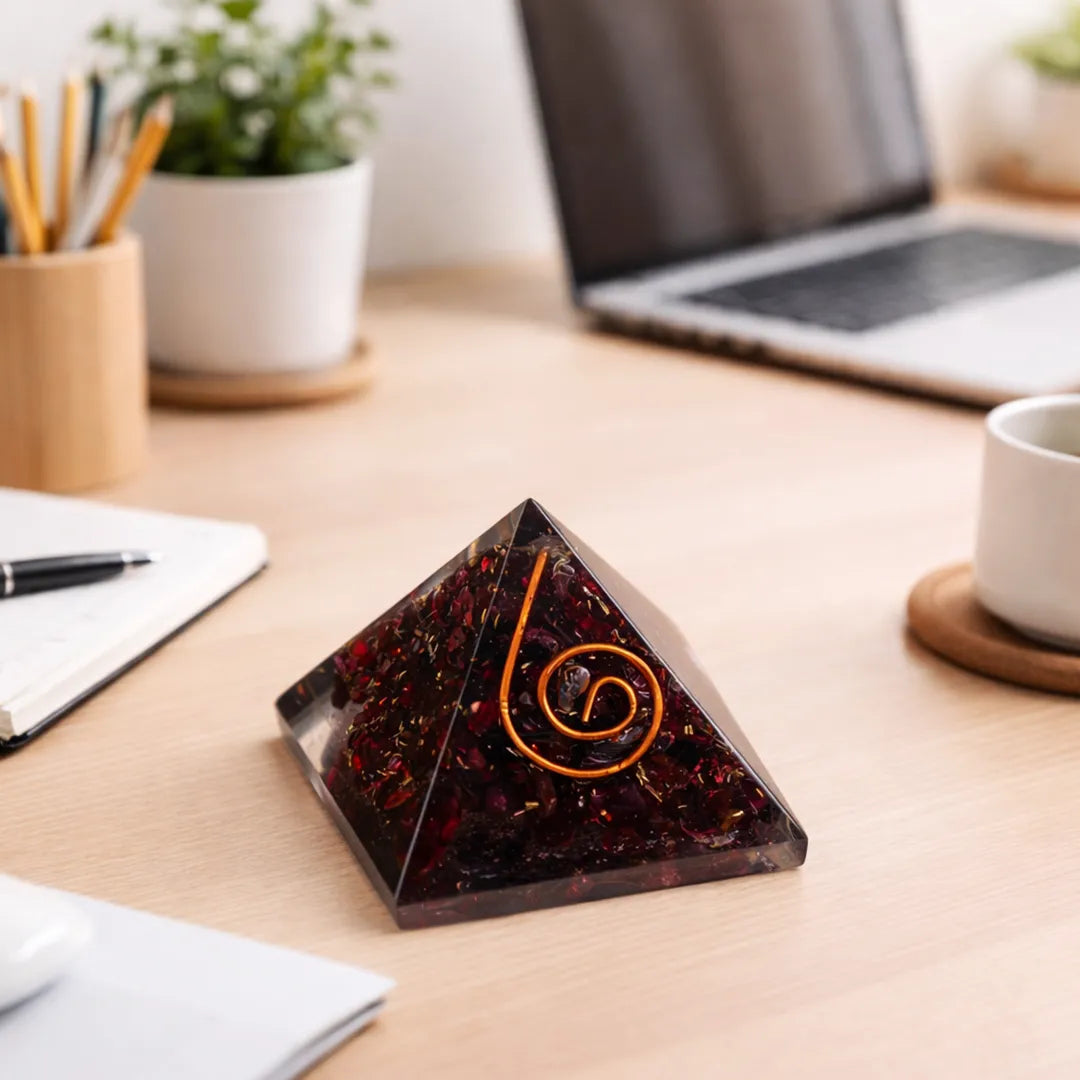 Pyramid-shaped object with a spiral design on a desk with a laptop and office supplies.