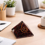 Pyramid-shaped object with a spiral design on a desk with a laptop and office supplies.