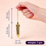 Gold pendulum held by a hand with measurements on a beige background