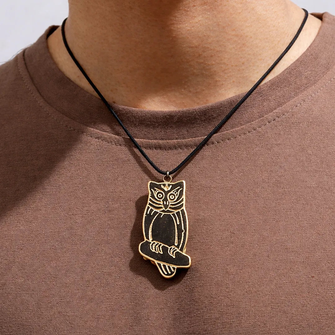 Owl pendant necklace on a person wearing a brown shirt
