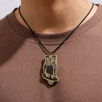 Owl pendant necklace on a person wearing a brown shirt