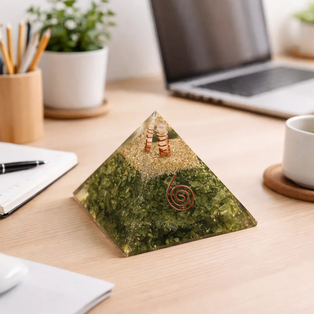 Decorative pyramid on a desk with laptop, notebook, and cup in the background