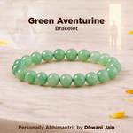 Green aventurine bracelet on a wooden surface with text indicating brand and product details.