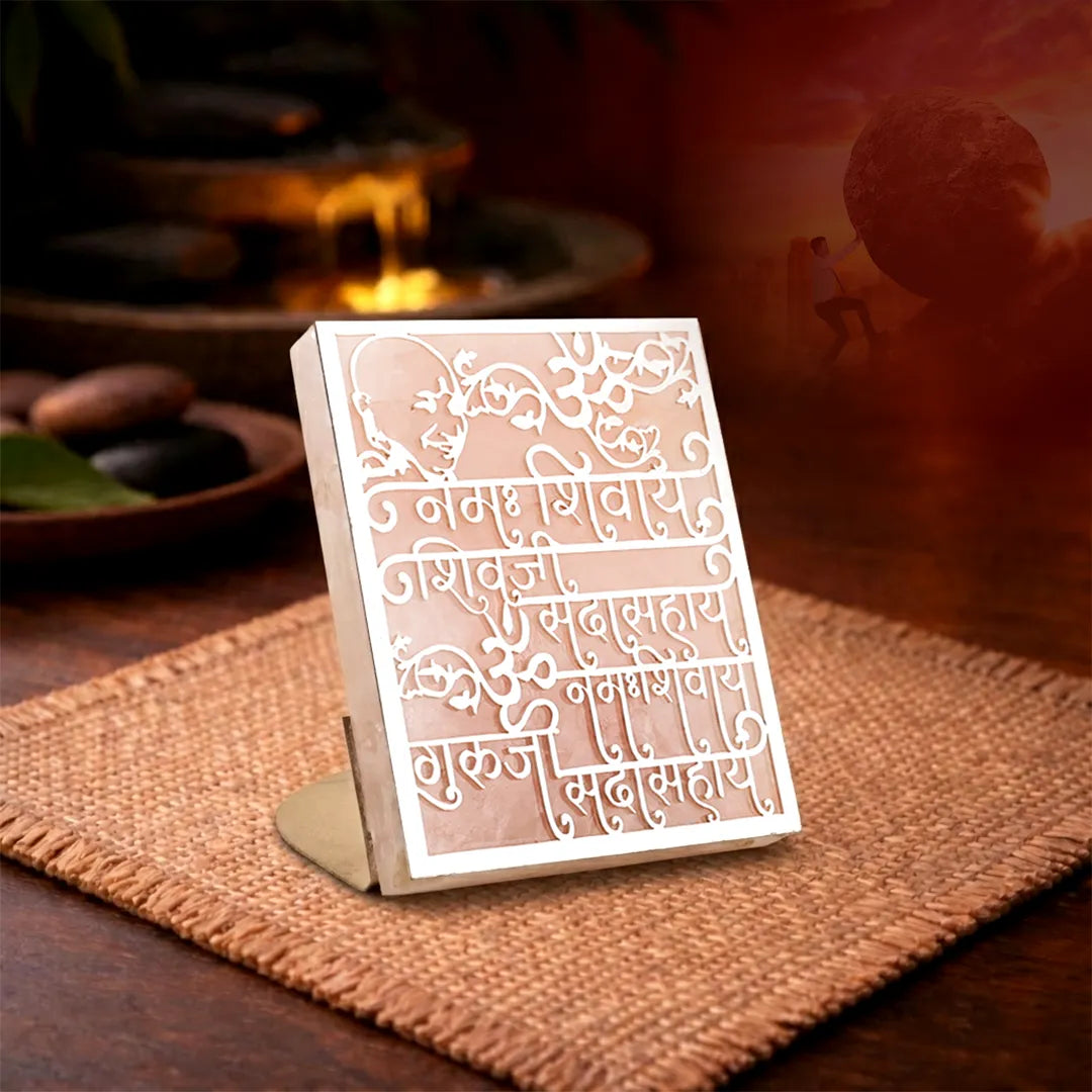 Decorative metal card with intricate designs on a wooden surfaceGuru Ji Mantra Rose Quartz Candle Stand for Blessings & Peace
